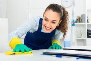 professional cleaner in working overall  dusting in modern office